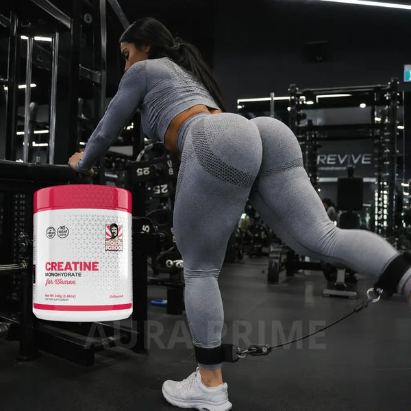 Tarro de Creatina para Glúteos 240 g de Aura Prime sostenido por una mujer joven en un gimnasio de Colombia