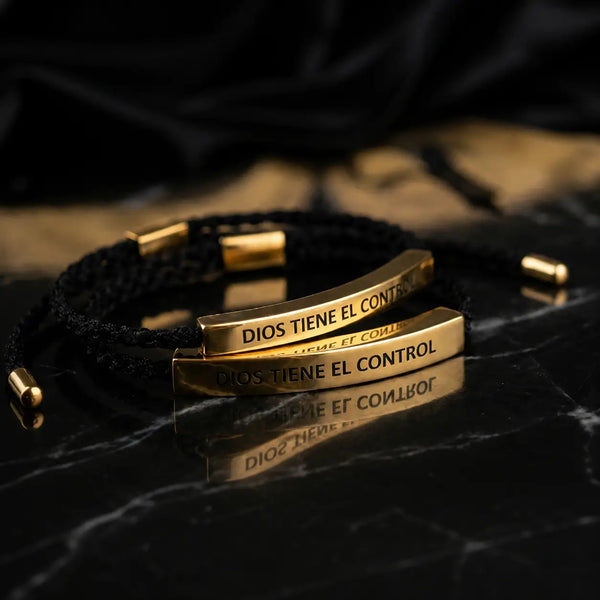 Caja de Lujo abierta con las dos pulseras Dios Tiene el Control, la negra y la roja, listas para regalar