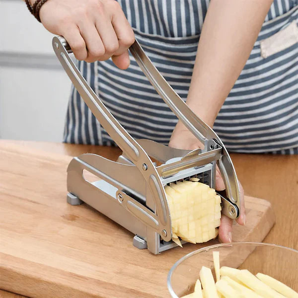 Cortador manual de papas en acero inoxidable sobre la mesada de una cocina colombiana