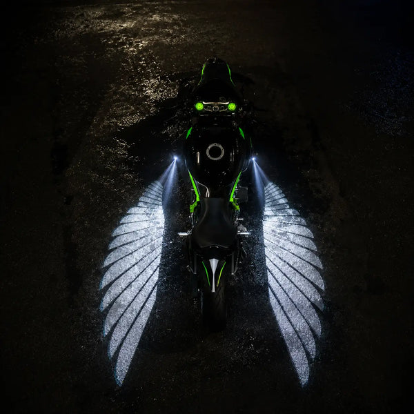Moto encendida de noche proyectando alas de luz roja en el asfalto de Bogotá