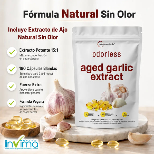 Mano de mujer adulta sosteniendo una softgel dorada de extracto de ajo añejado