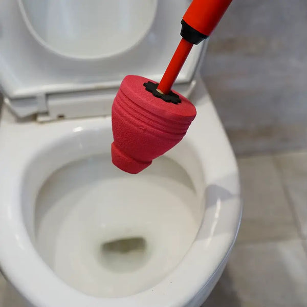 Tapón sellador del destapador sostenido sobre un sanitario blanco